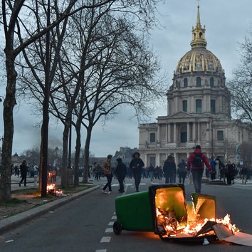 A fire sat by demonstrators protesting against the government after pushing the pensions reform without a vote using...